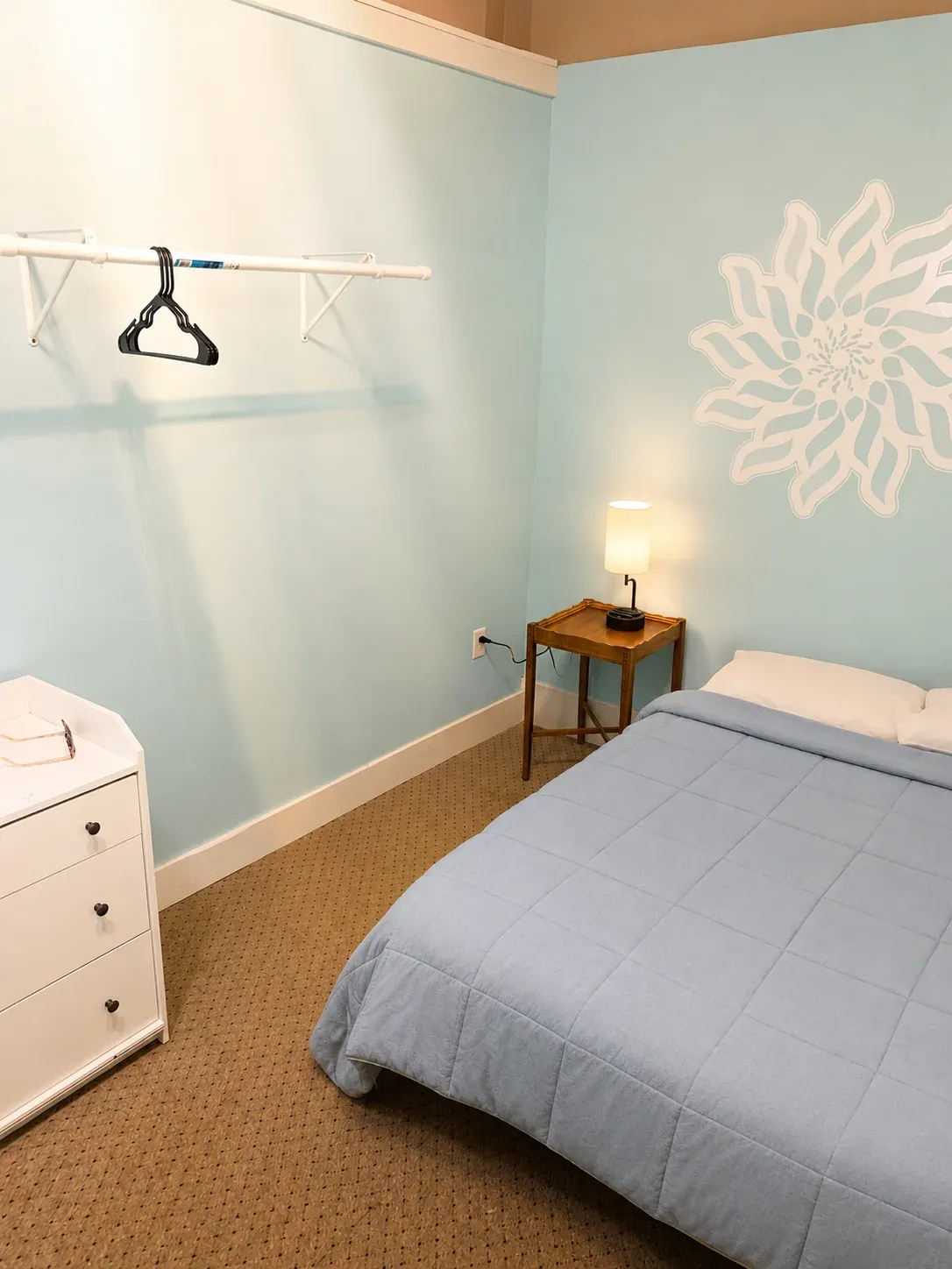 Light blue Annex room with flower mural and full bed
