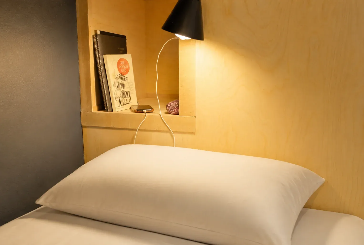 Full-size pod bed with pillow and warm reading lamp