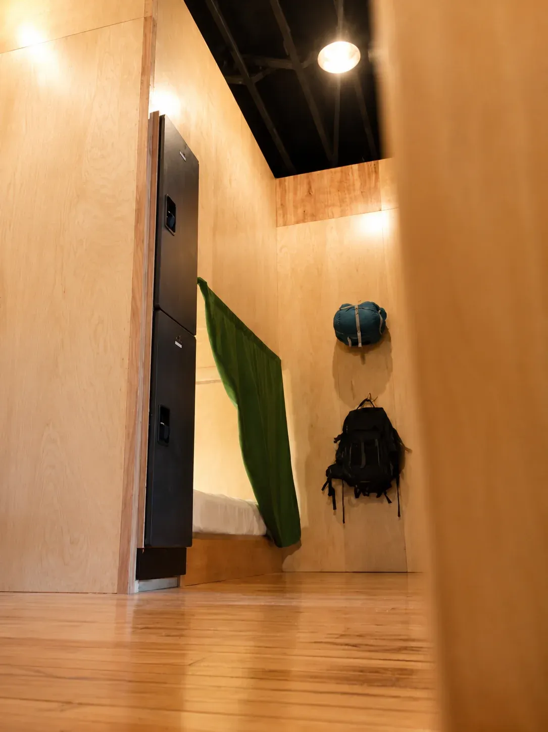 Pod entrance with locker and hanging backpack in the dorm hallway